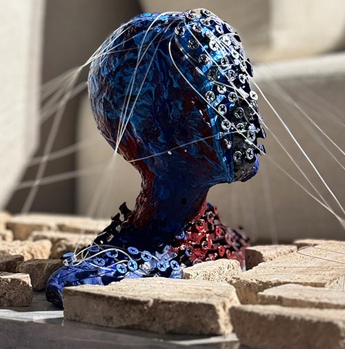 Epoxy sculpture of a female head with expressive texture and fluid motion, combining matter and gesture.