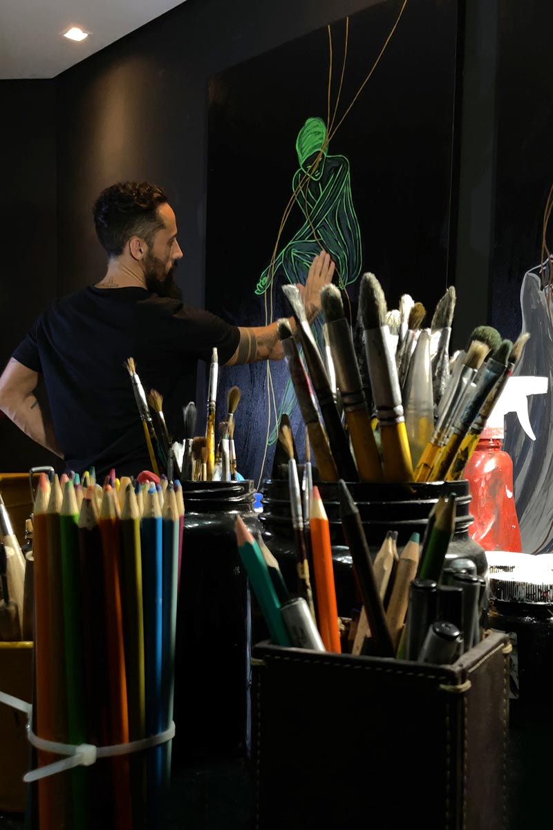 Brazilian artist Juca Máximo painting in his studio, captured mid-process during the creation of a vibrant green Energy Series piece.