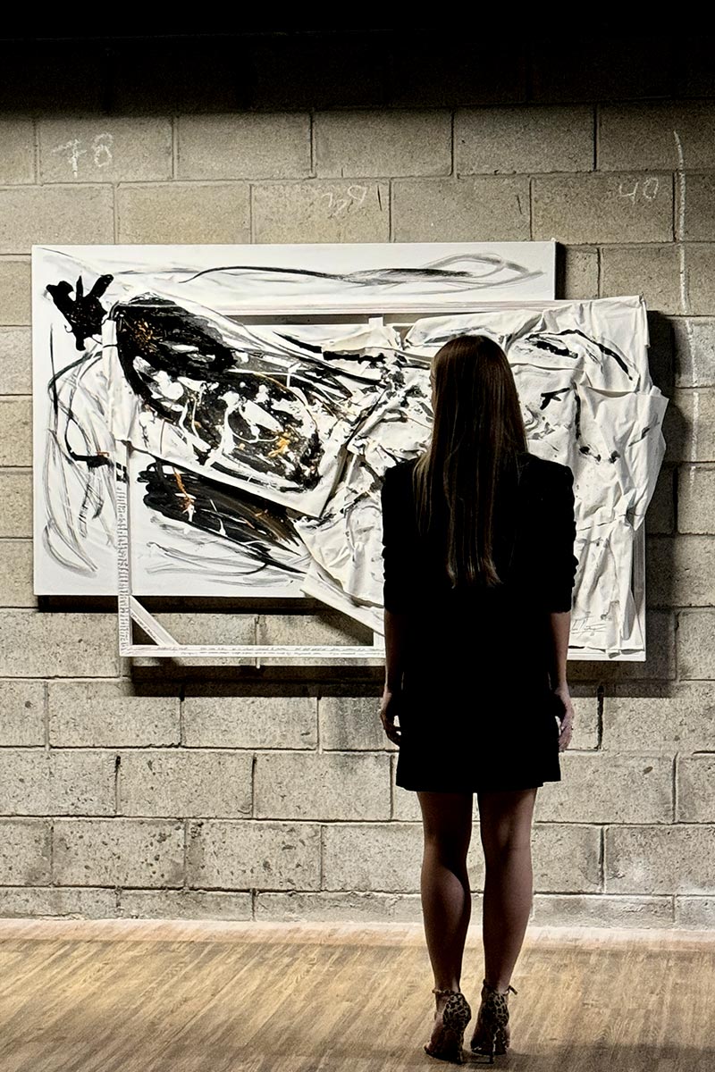 Female visitor admiring large-scale abstract painting by Juca Máximo — a textured exploration of inner freedom and emotional release in artistic form.