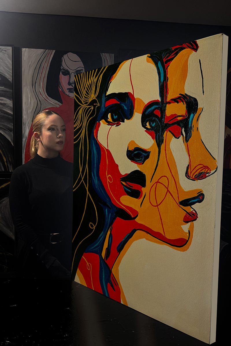 Collector observing “Write Your Story II” by Juca Máximo — an original hand-painted artwork exploring feminine duality, emotional memory, and transformation. Photographed inside the artist’s studio, part of the Buy Original Art collection.