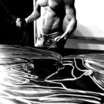 Brazilian artist Juca Máximo painting Gravity XV shirtless in his studio — a gestural, emotional artwork created through body movement, breath and physical presence.