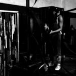 Artista soldando escultura em ferro no estúdio, utilizando máquina de solda em estrutura metálica da série Energy, explorando tensão, fogo e construção física da obra em processo. Artist welding an iron sculpture in the studio, using a welding machine on a metal structure from the Energy series, exploring tension, fire, and the physical construction of the artwork in process.