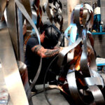Juca Máximo welding a contemporary steel sculpture in his studio. / Juca Máximo soldando uma escultura contemporânea em aço no ateliê.